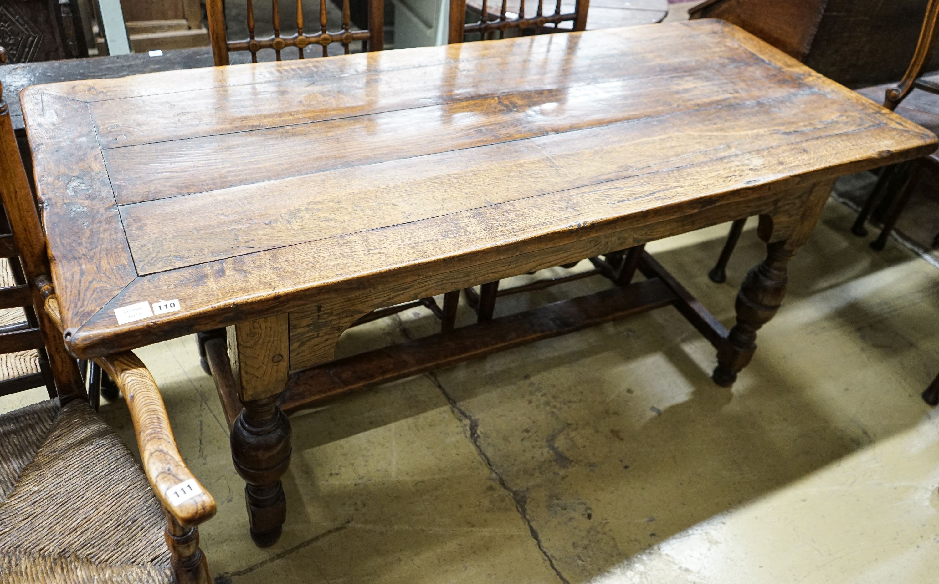 A 17th century style oak refectory table, with cup and cover legs and H stretcher, length 177, depth 74cm, height 77cm